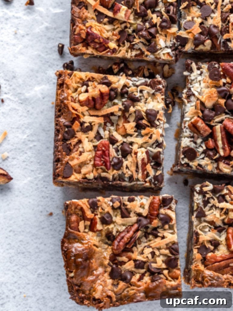 Golden Coconut Dream Bars 6 Top-down photograph showing perfectly cut pieces of magic bars arranged, displaying their distinct layers and tempting texture.