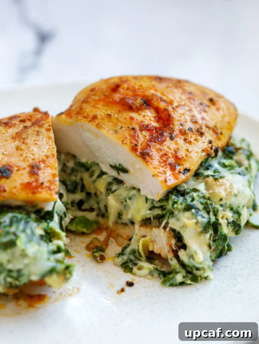 Creamy Spinach Artichoke Stuffed Chicken 2 Close up of Spinach stuffed chicken breast cut in half, revealing creamy filling.