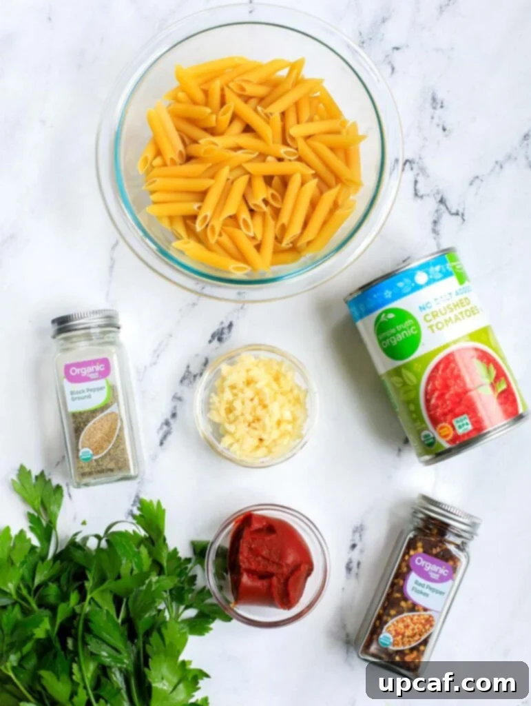 Raging Inferno Pasta 3 All the fresh ingredients laid out, including penne pasta, tomatoes, garlic, and spices, for making spicy arrabbiata.