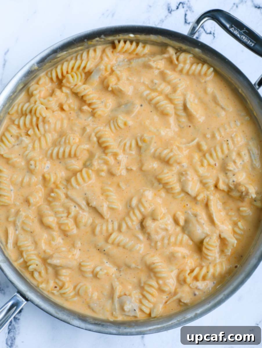 Fiery Buffalo Chicken Pasta Bake 11 Mixed in pasta, chicken, and sauce in a pot.