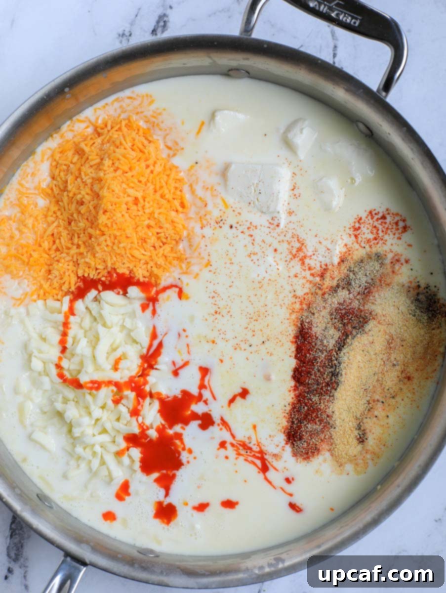 Fiery Buffalo Chicken Pasta Bake 8 Adding spices to the sauce in a pan.