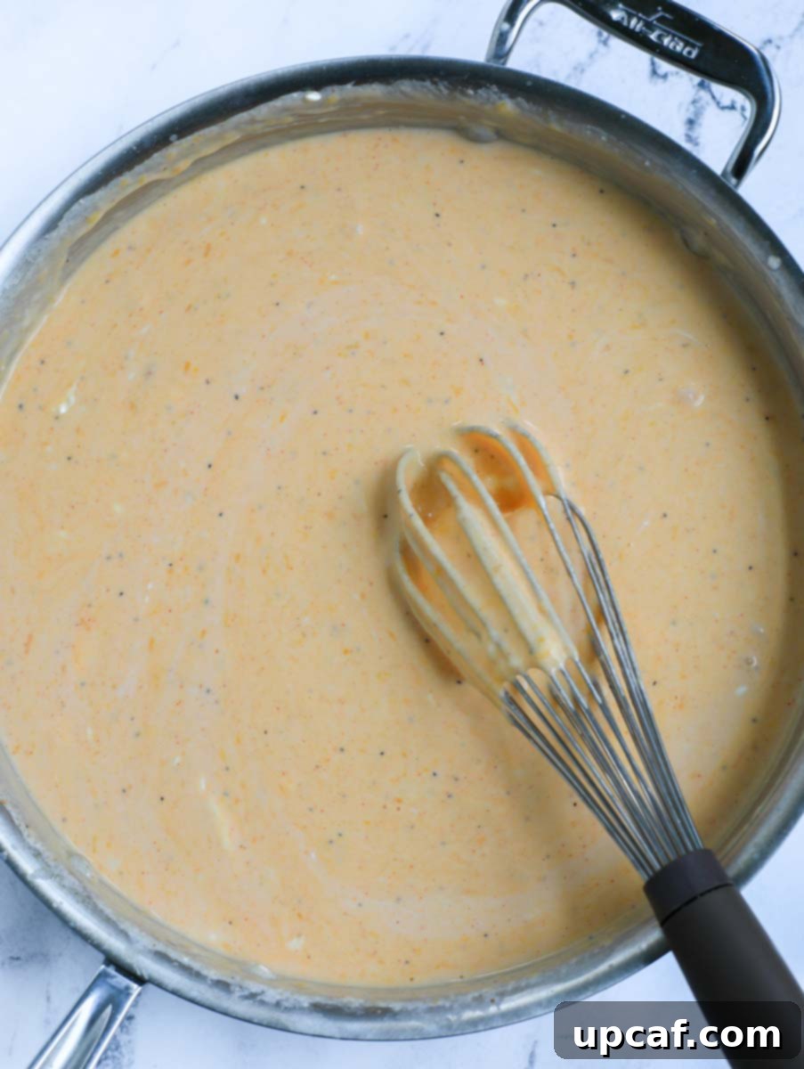 Fiery Buffalo Chicken Pasta Bake 9 Whisking sauce ingredients together for Buffalo chicken mac and cheese.