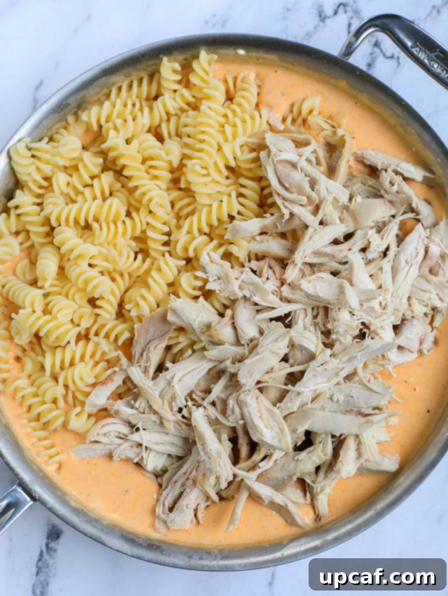 Fiery Buffalo Chicken Pasta Bake 10 Pasta and chicken in pot with sauce, before final mix.