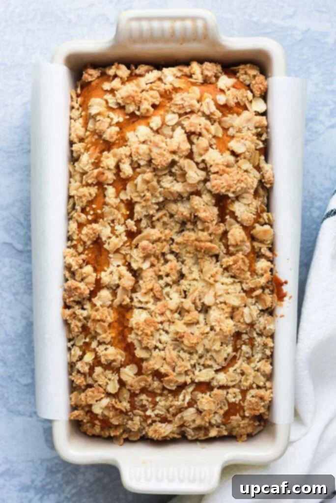 Overhead shot of easy pumpkin bread in a white loaf pan, fresh from the oven.