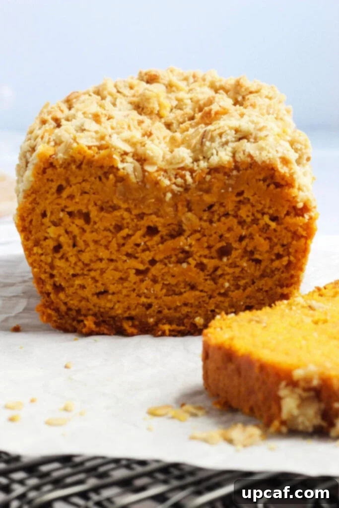Close up of sliced easy pumpkin bread on a rustic table, highlighting its texture.