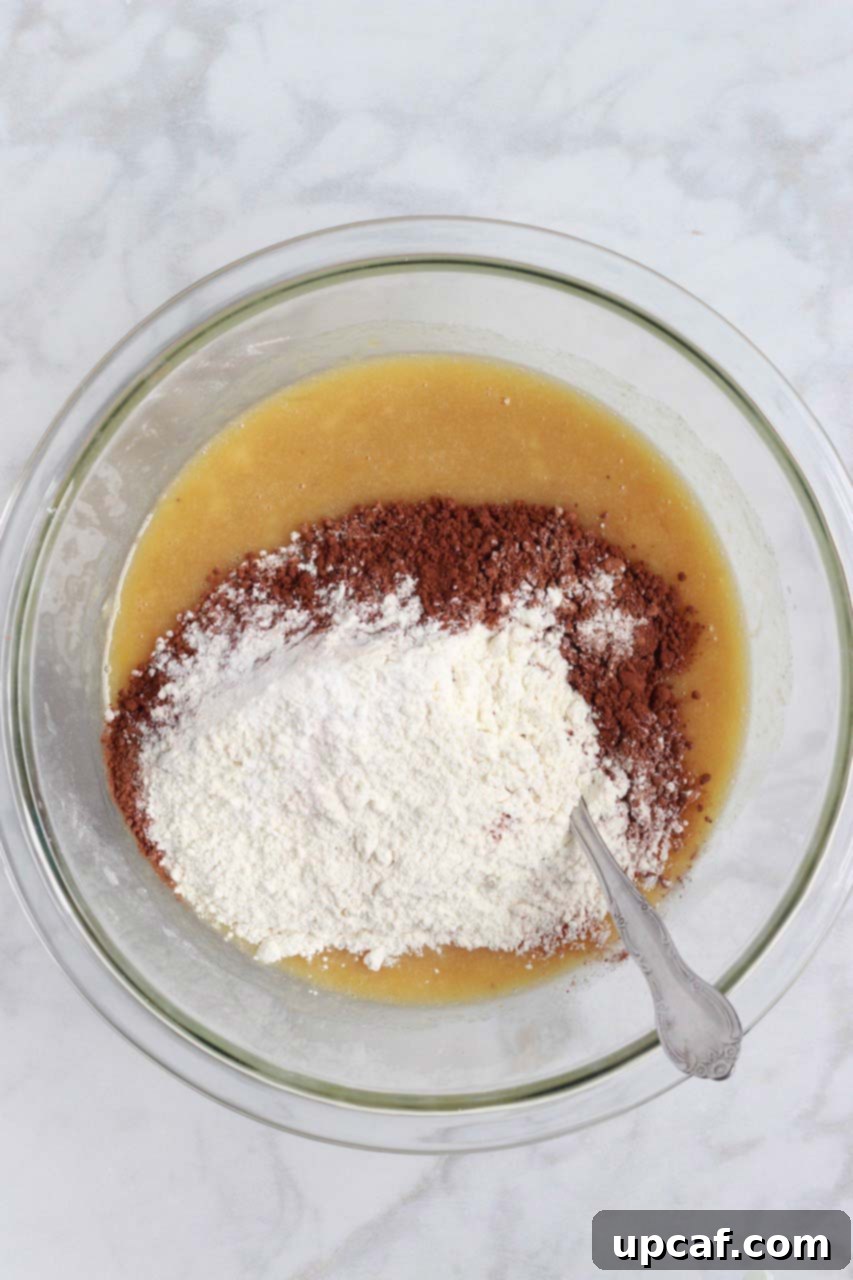 Dry ingredients in one bowl and wet ingredients in another, prepared for mixing to make chocolate banana bread.