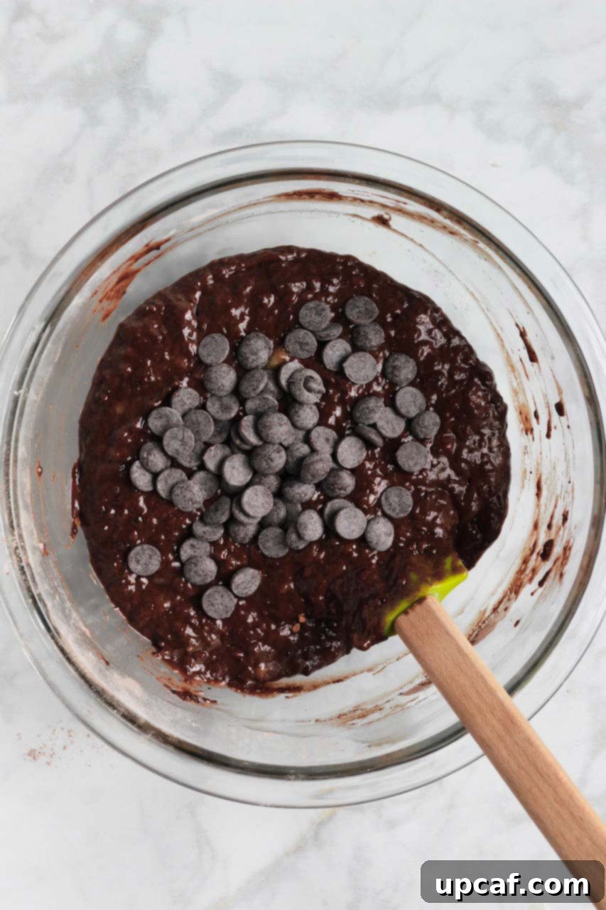 Chocolate banana bread batter after mixing, with chocolate chips folded in, ready to be poured into the loaf pan.