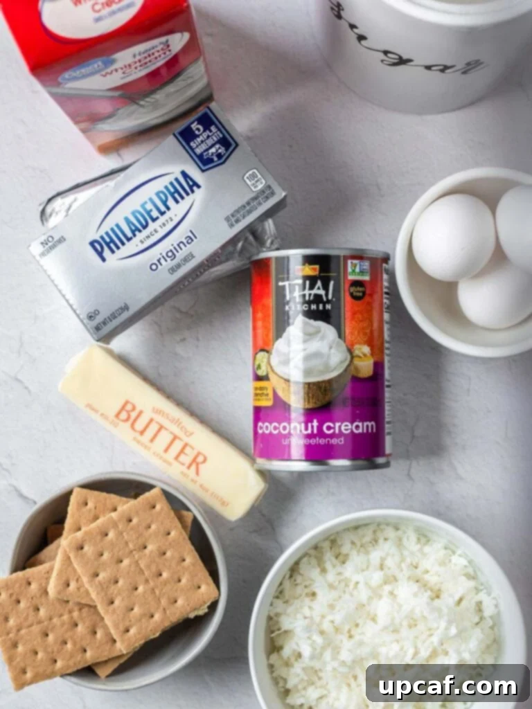 All the essential ingredients for making coconut cheesecake bars laid out on a rustic wooden surface, highlighting freshness and quality