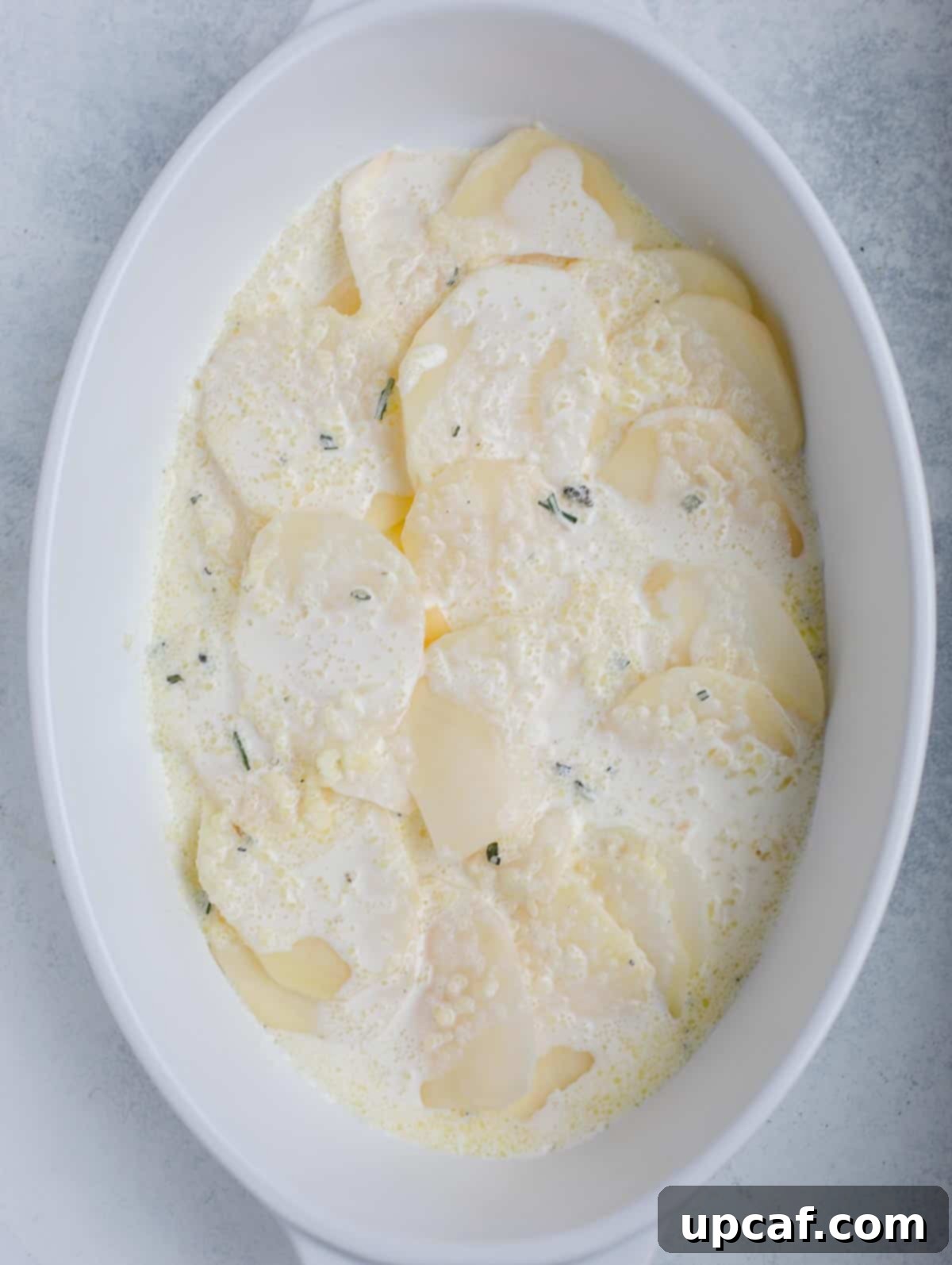 Another step-by-step image illustrating the meticulous layering process for au gratin potatoes.