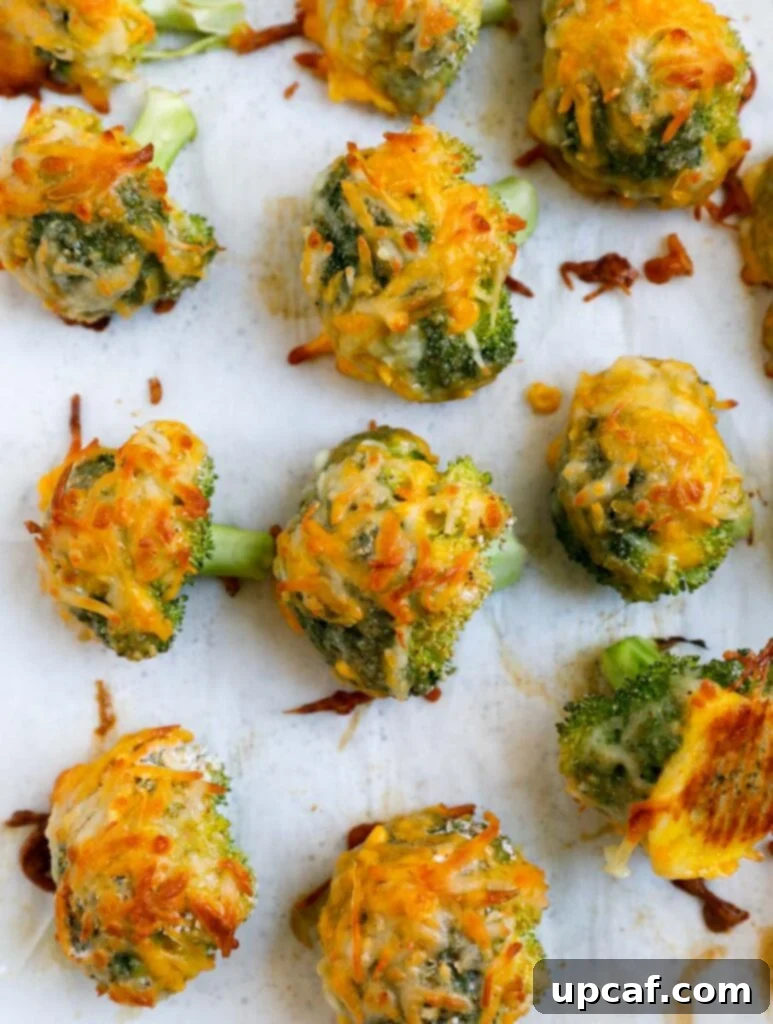 Cheesy broccoli bites on a baking sheet.