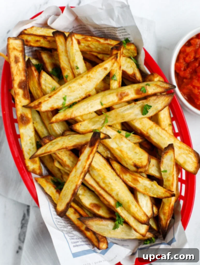 Top down shot of sweet potato fries in a red basket.