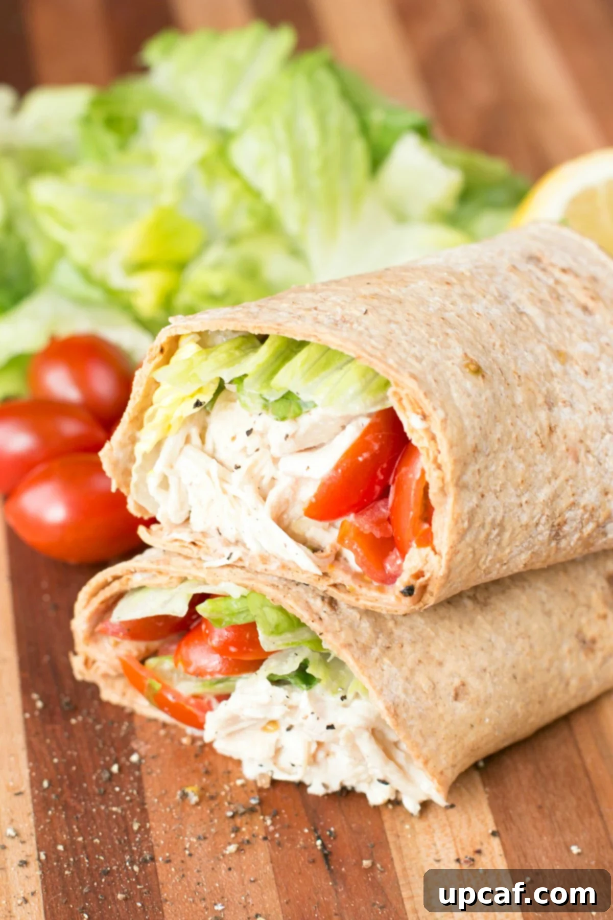 Fast and Fresh Chicken Caesar Wraps 3 Close up picture of a chicken caesar wrap sliced in half on a cutting board