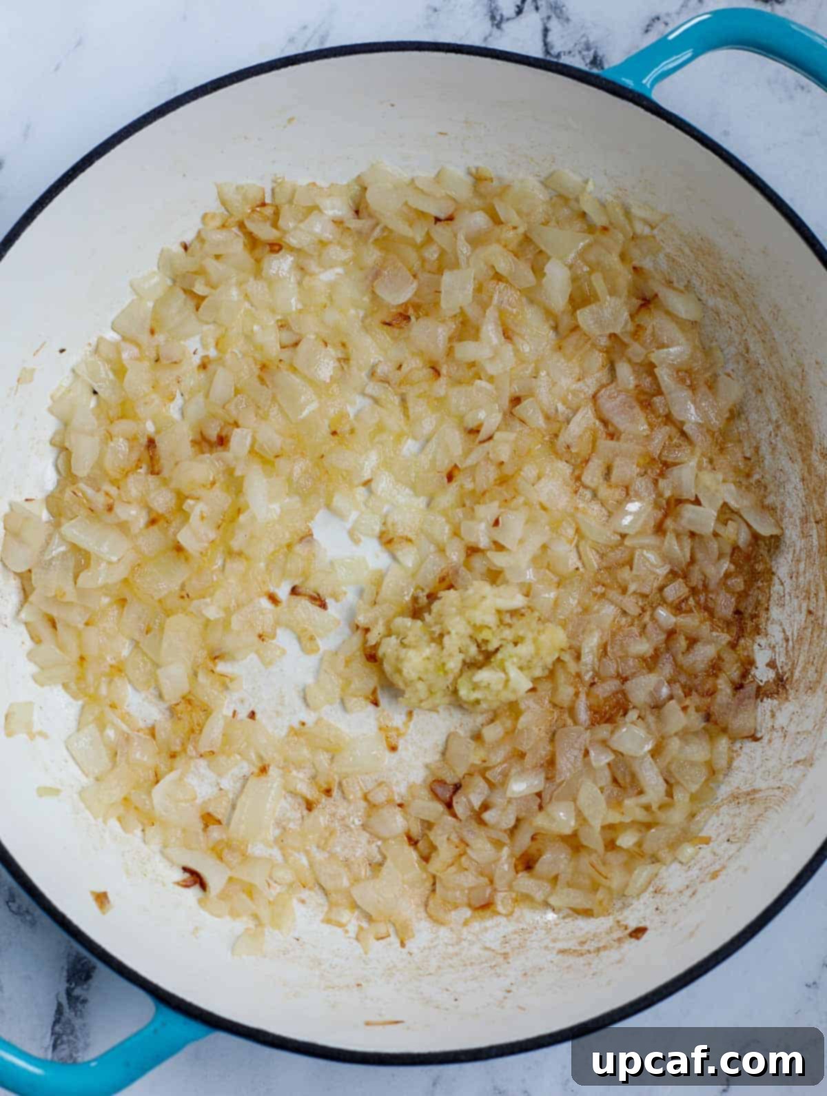 Ultimate Homestyle Green Bean Casserole 4 Close-up shot of sautéed onions and garlic in a pan, lightly golden and aromatic.