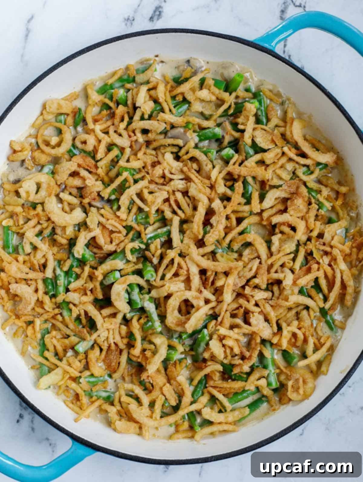 Ultimate Homestyle Green Bean Casserole 7 Green bean casserole topped with crispy fried onions, ready for baking.