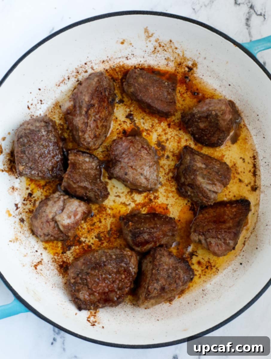 Beef cooking in a dutch oven.