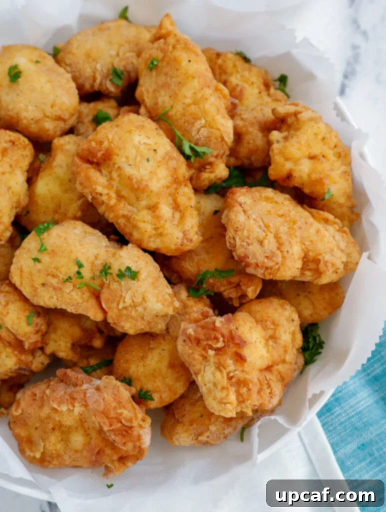 Top down view of chicken nuggets on a plate with dipping sauce.