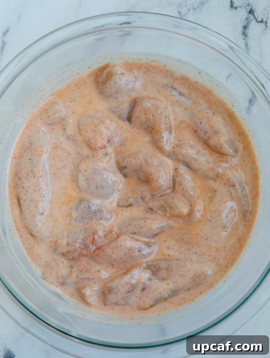 Overhead shot of tenders marinating in a bowl.