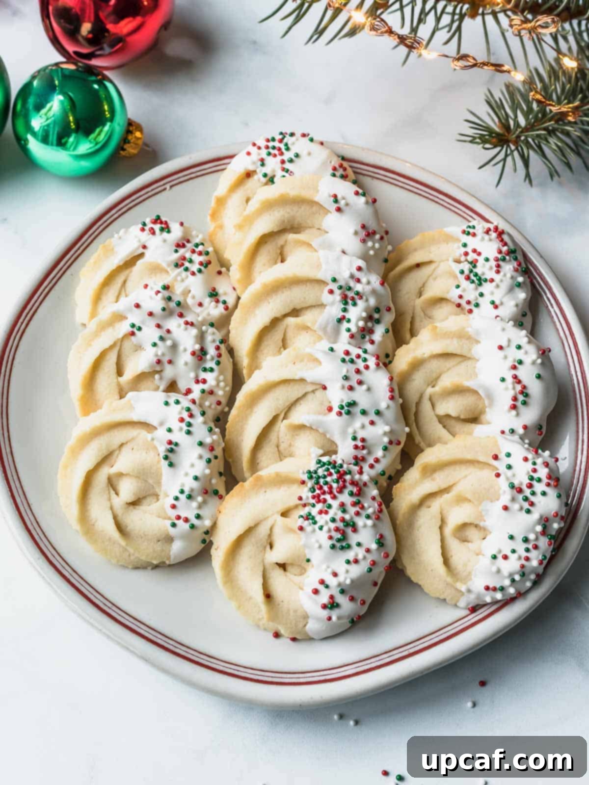 danish butter cookies dipped in white chocolate and sprinkles with red and green sprinkles