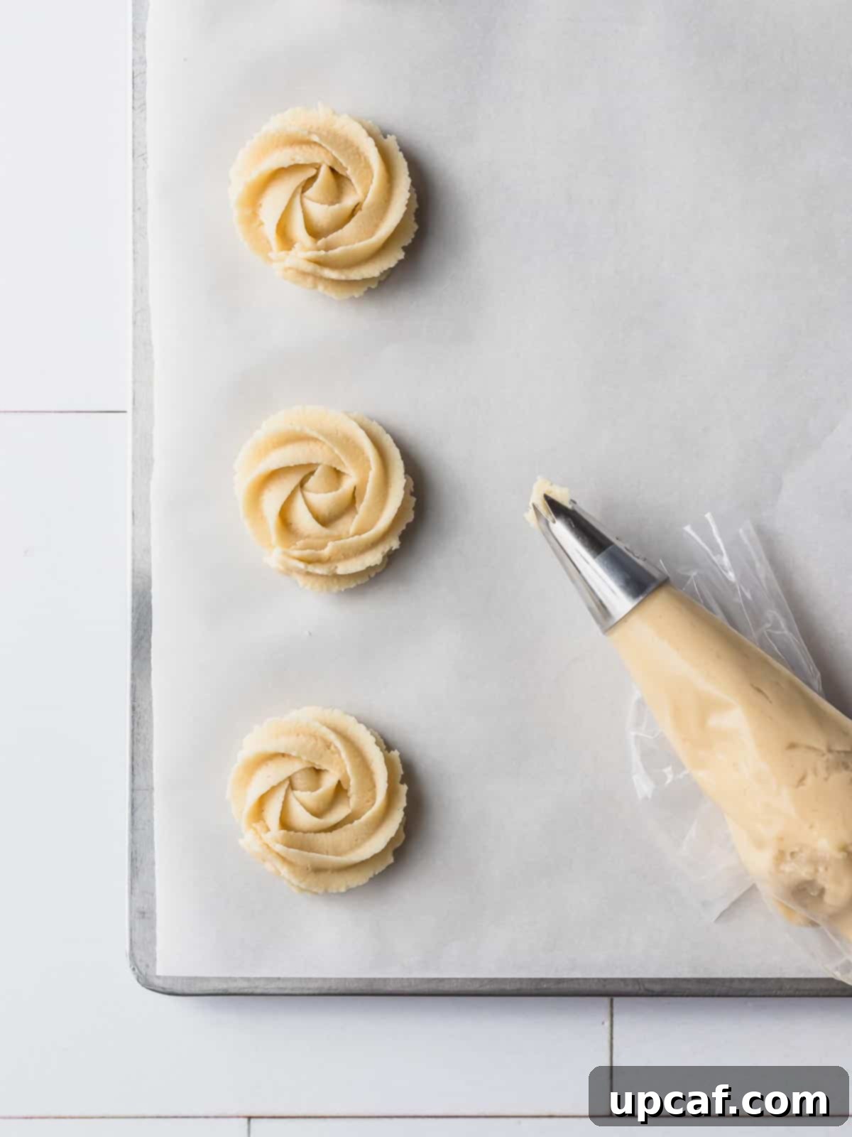 danish cookies being piped on a baking pan