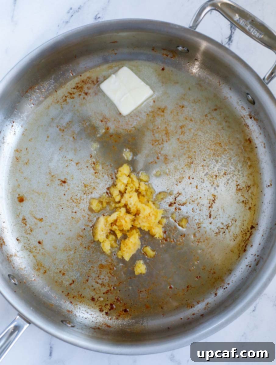 Minced garlic and butter sizzling in a skillet, forming the base of the sauce.