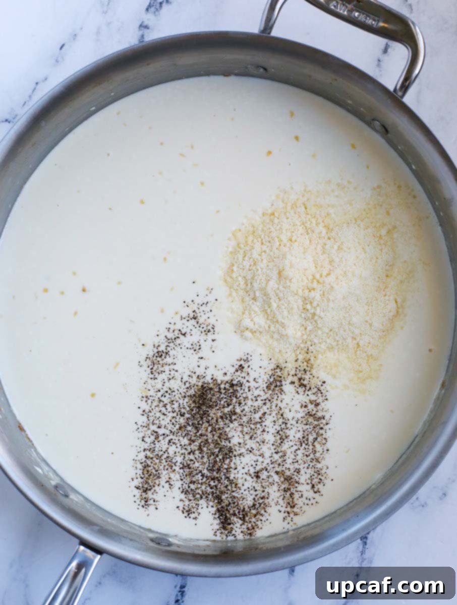 A creamy sauce with seasonings simmering in a pot, thickening to perfection.