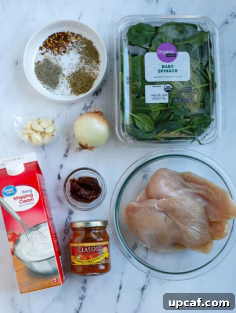 Ingredients for creamy tuscan chicken laid out on a wooden surface.