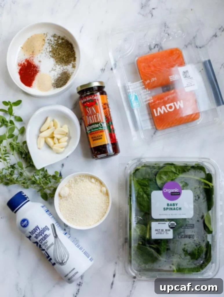 Top down view of all the fresh ingredients laid out for making creamy tuscan salmon.