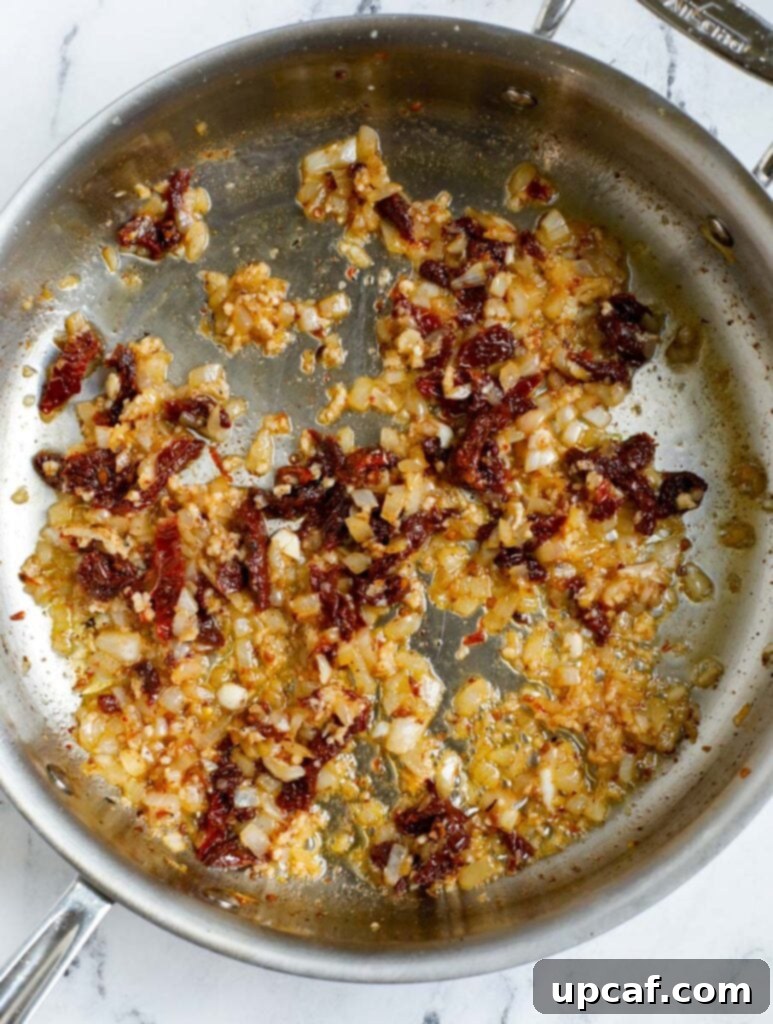 Garlic and dried oregano being added to the skillet.