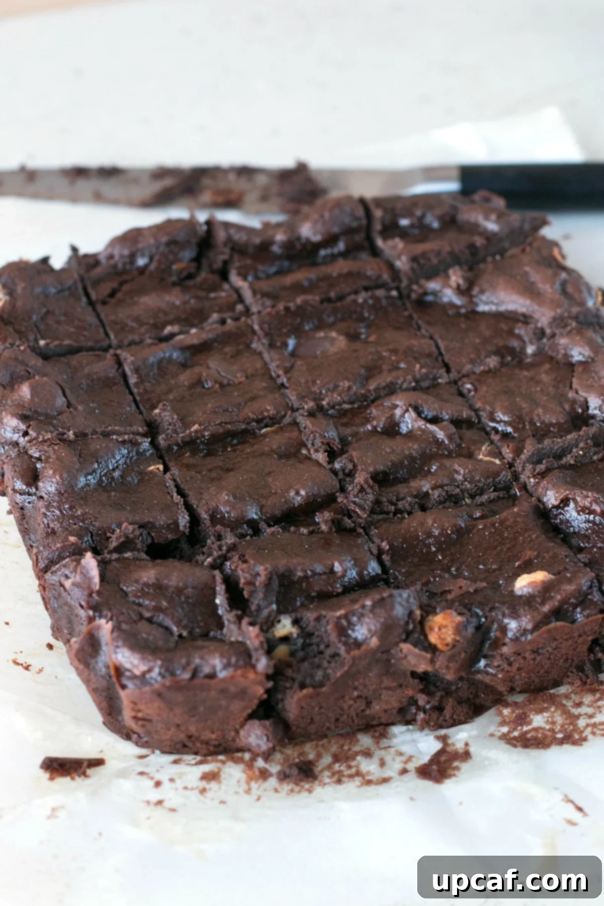 Triple Chocolate Avocado Brownies sliced into squares on parchment paper