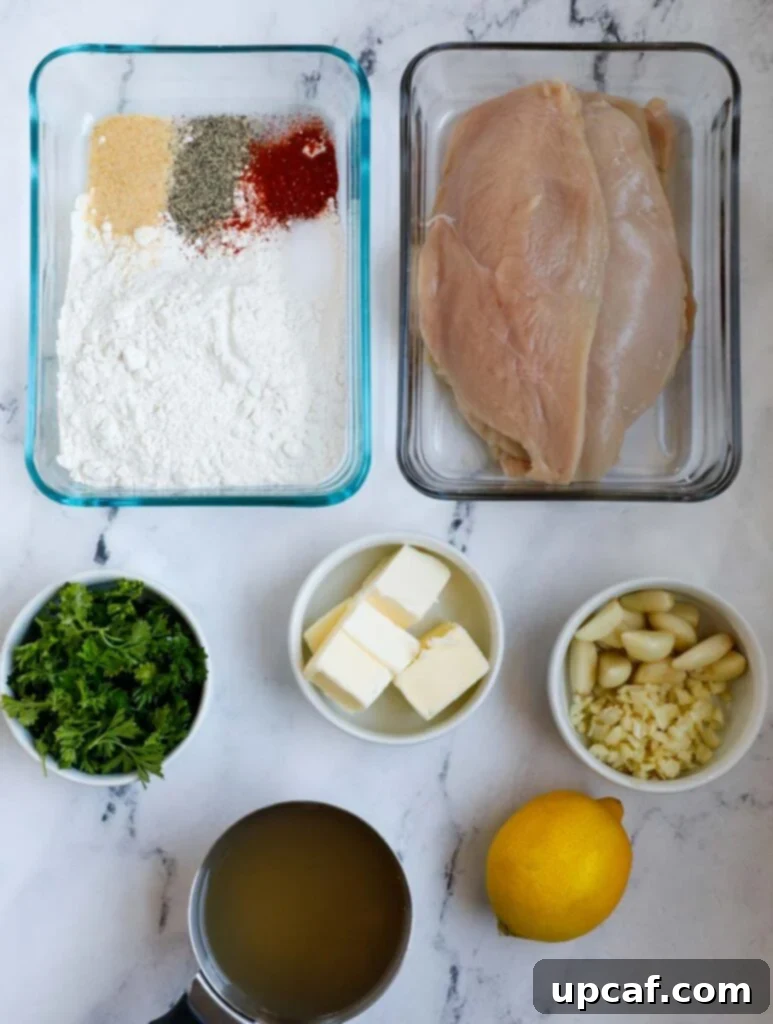 Top down shot of ingredients for lemon and garlic chicken, including chicken breasts, lemons, garlic, butter, and spices.