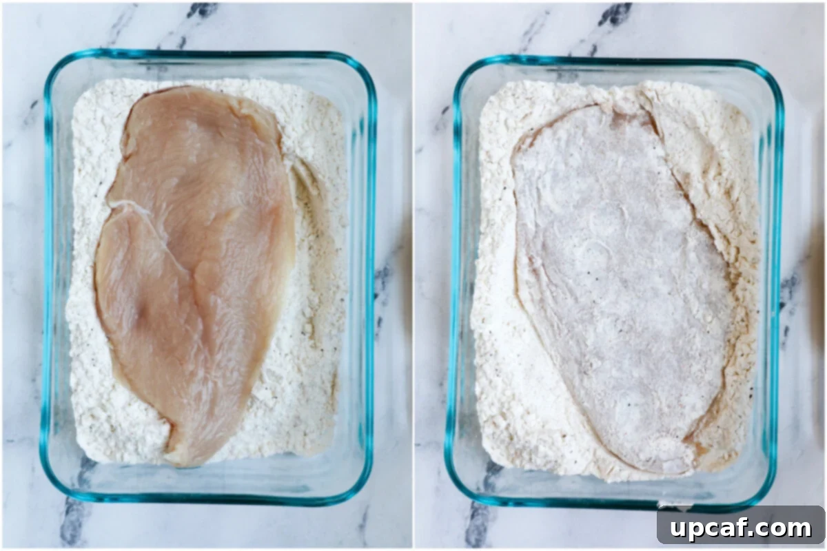 Top down shot of chicken pieces being coated in a flour and spice mixture in a bowl.