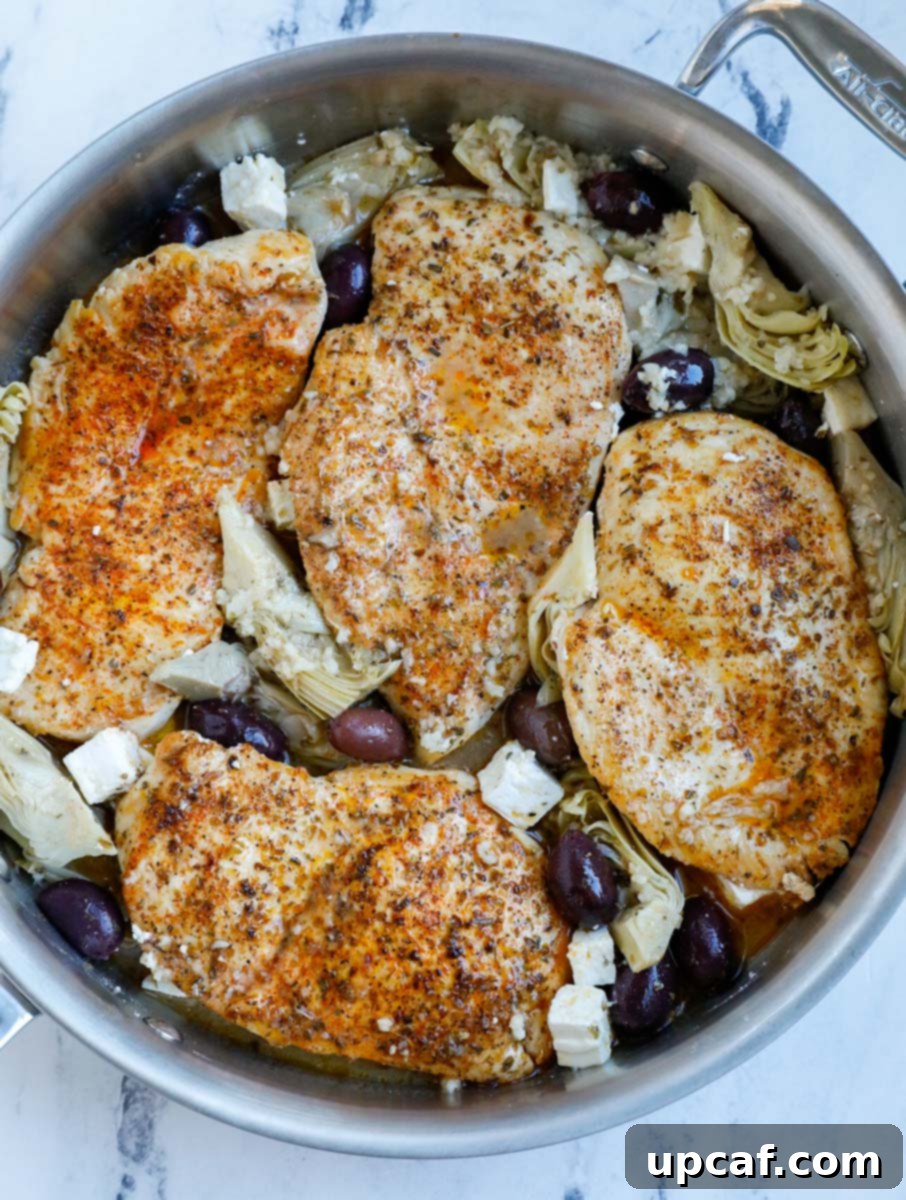 Chicken in a pot with olives and artichokes, ready for the sauce.