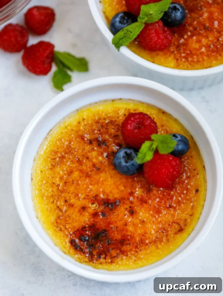 Effortless Crème Brûlée 11 A top-down view of two perfectly prepared crème brûlée desserts in ramekins, ready to be enjoyed.