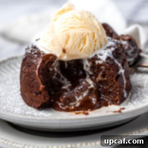 A lava cake cut opened with a scoop of ice cream on top.