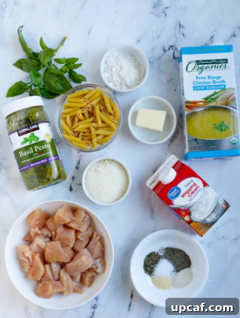 A vibrant flat lay showcasing all the fresh ingredients needed to prepare a pesto pasta with chicken, including pasta, chicken, basil, cream, and cheese.