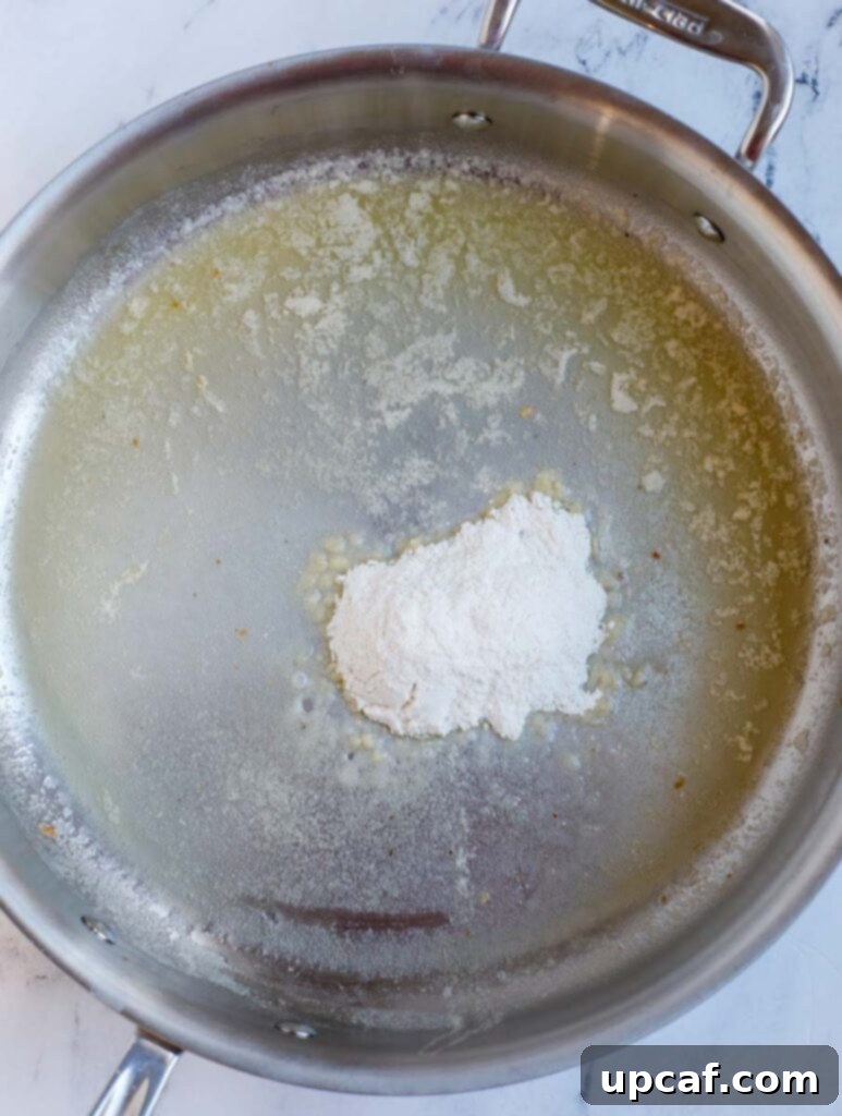 Melted butter and all-purpose flour creating a roux in a hot pan.
