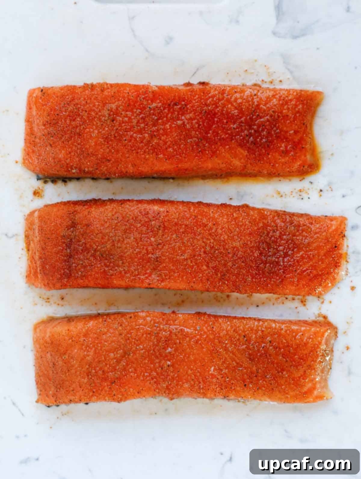marinated salmon on a cutting board.