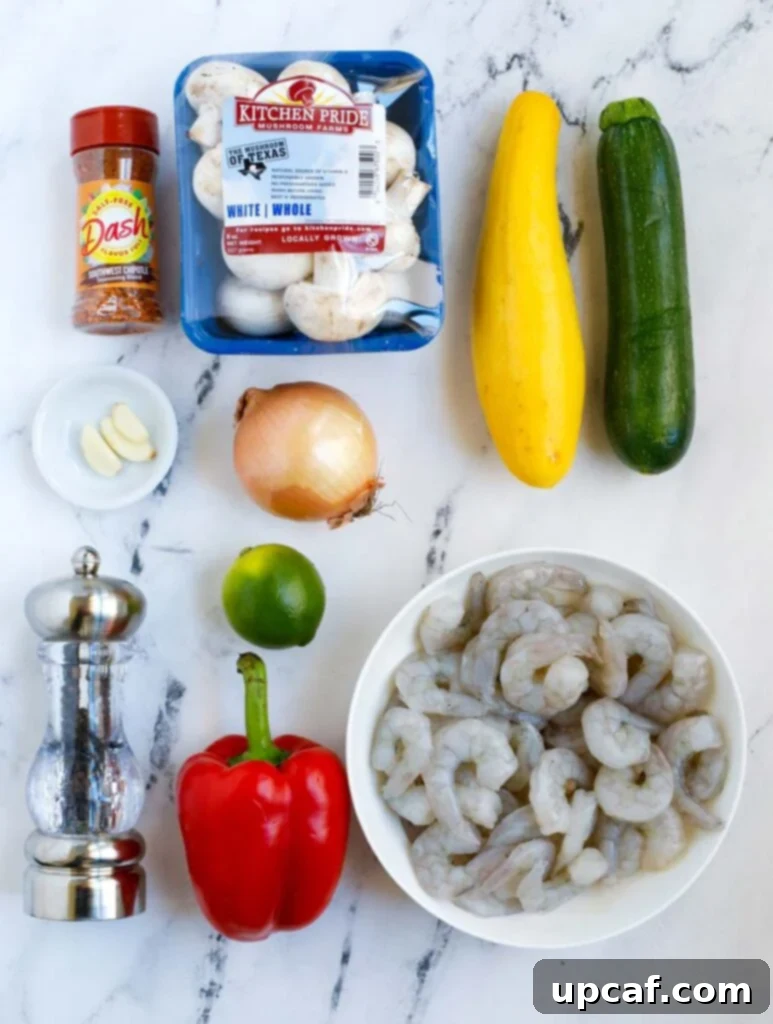 Top down shot of all fresh ingredients for air fryer shrimp and vegetables laid out on a clean surface.