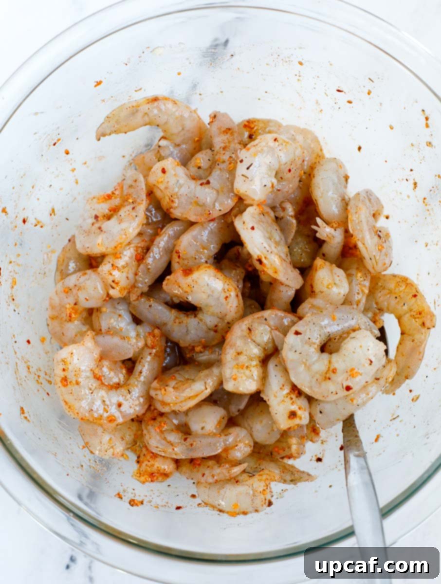 Shrimp being coated in a rich, spicy seasoning mixture.