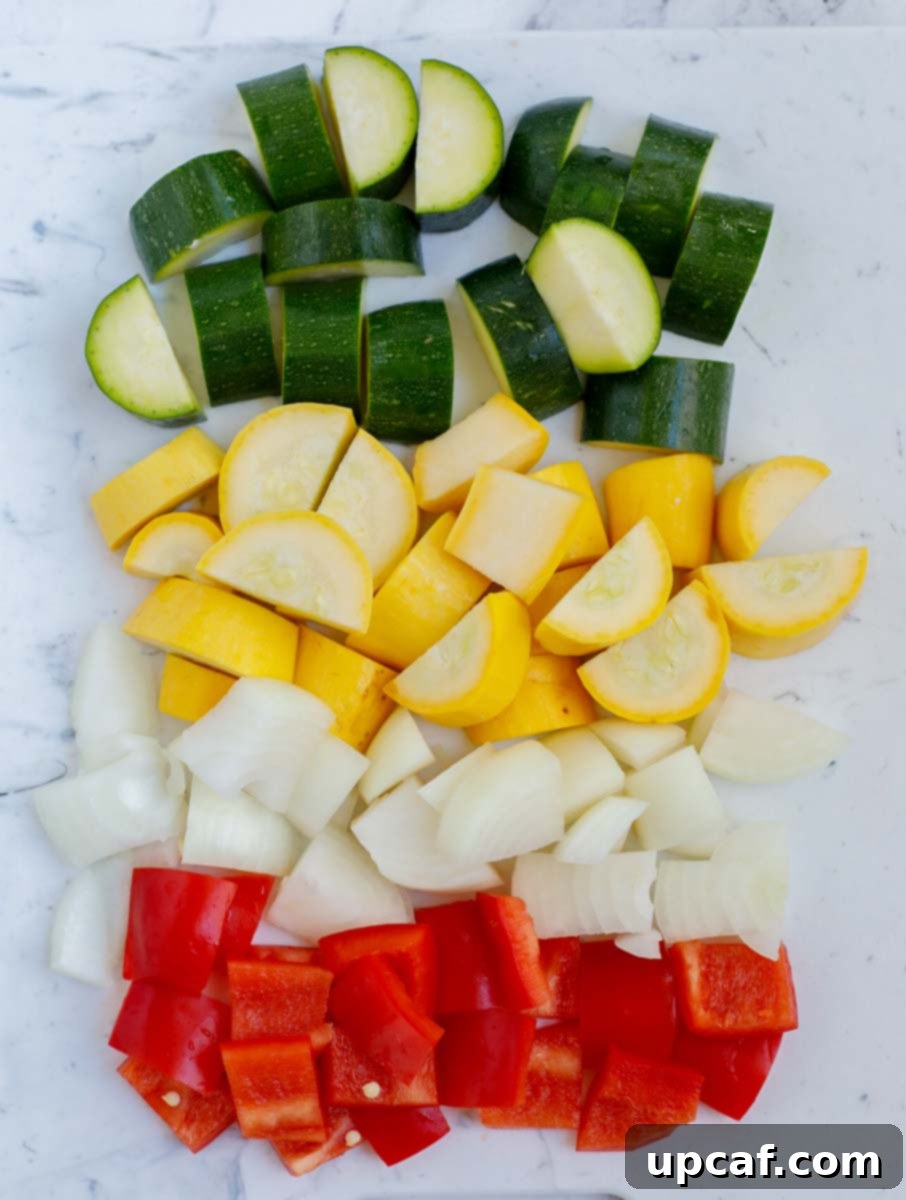 A vibrant assortment of diced vegetables on a cutting board, prepared for cooking.