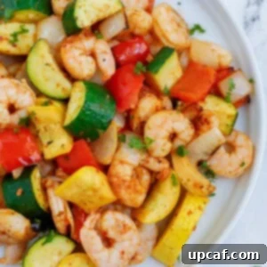 Top down shot of air fryer shrimp and vegetables on a plate.