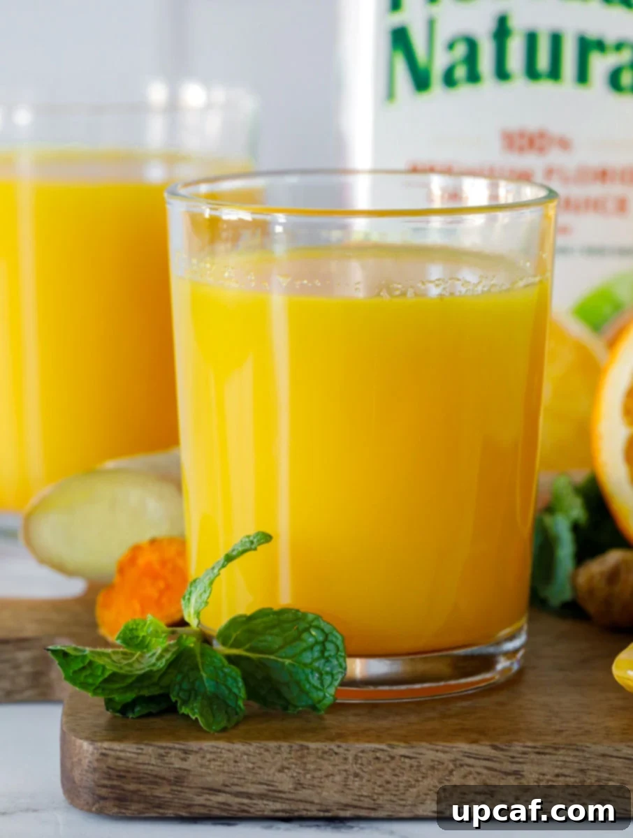 Close-up shot of the vibrant Orange-Ade Immune Booster Drink in a glass.