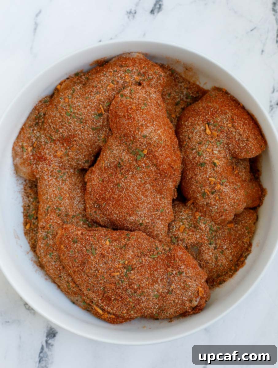 Crispy Juicy Air Fryer Boneless Thighs 4 Raw boneless chicken thighs in a bowl before marination.