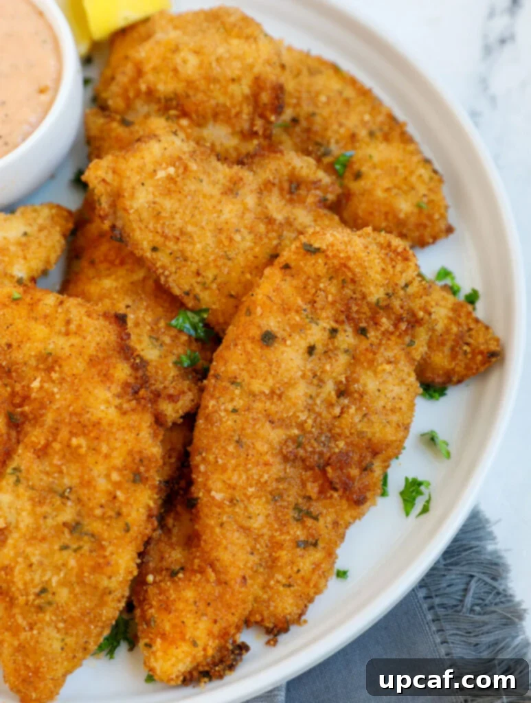 Top-down view of a plate filled with golden, crispy air fryer chicken tenders.