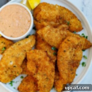 Chicken strips on a plate with sauce.