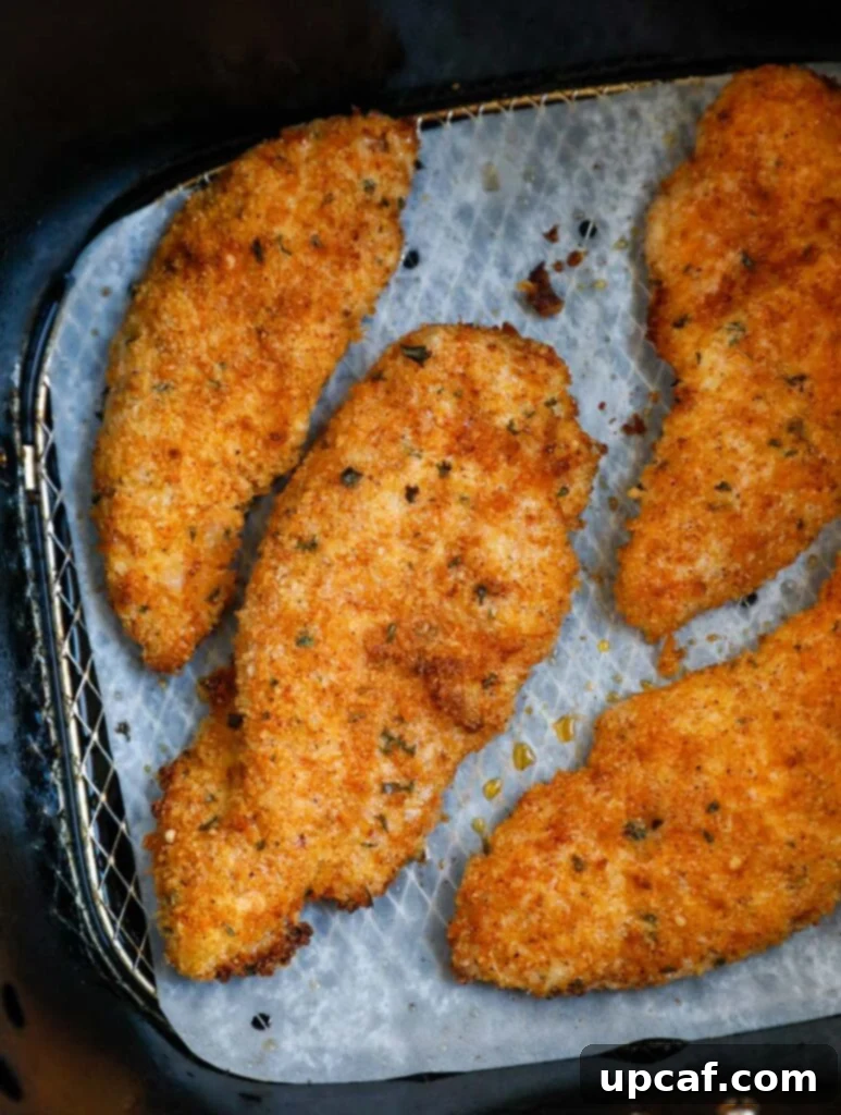 Perfectly crispy chicken tenders just removed from an air fryer.