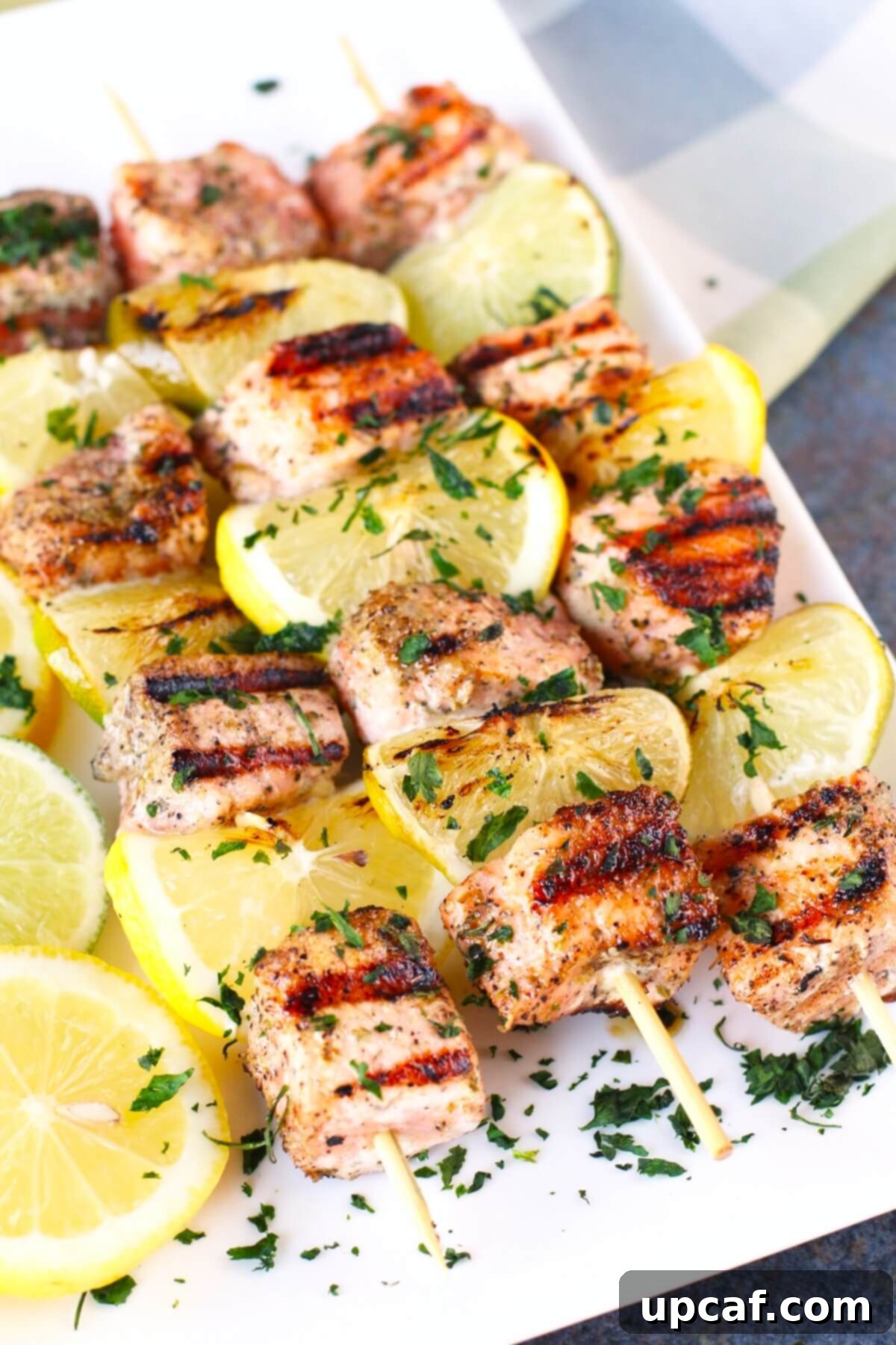 Zesty Salmon Kebabs 2 Grilled salmon and lemon kabobs beautifully arranged on a plate