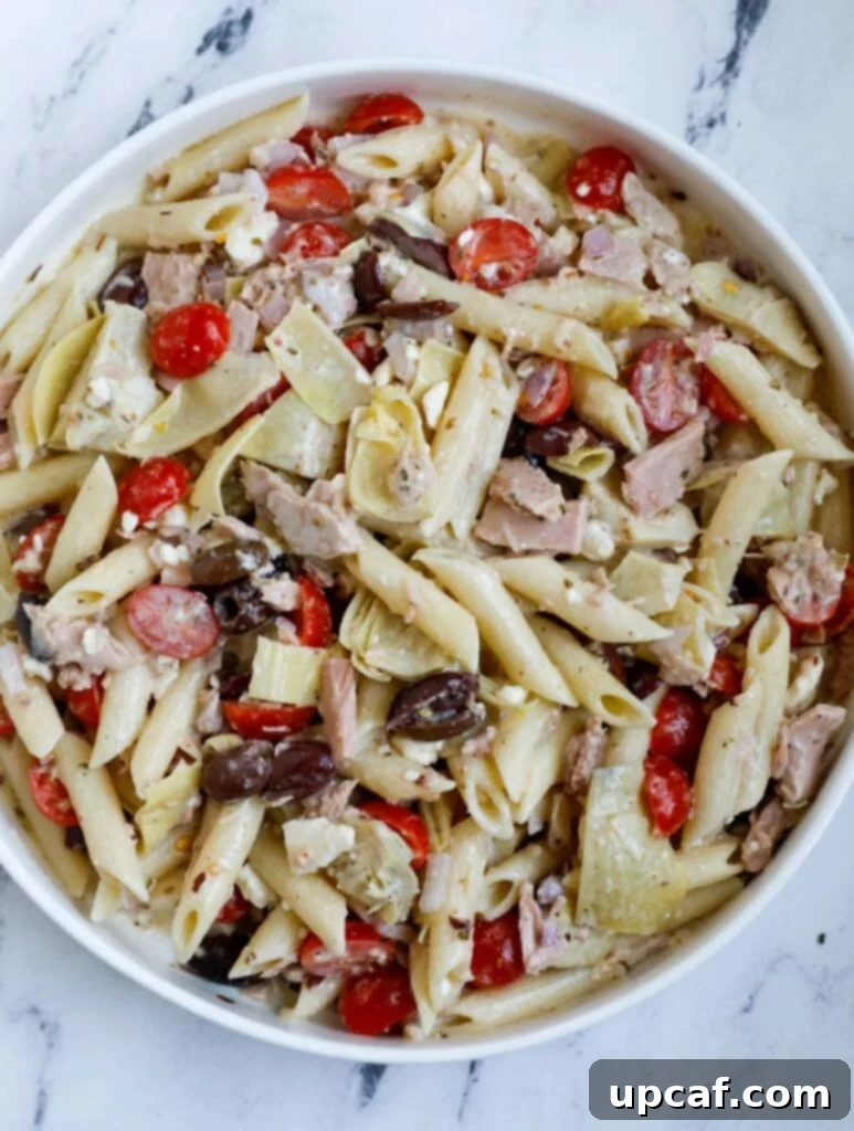 Top down shot of Greek Tuna Pasta Salad fully assembled in a large bowl.