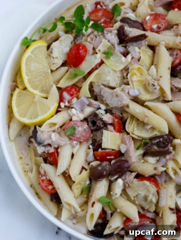Overhead view of Greek Tuna Pasta Salad in a big white bowl, ready to serve.