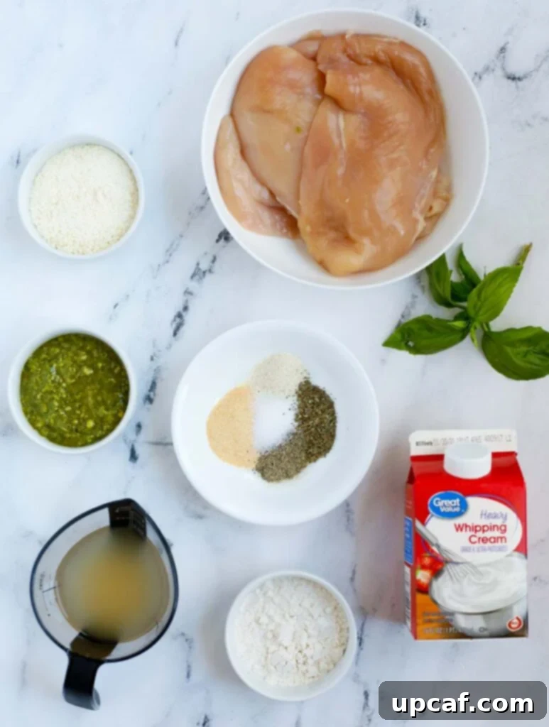 Top down shot of ingredients laid out for creamy pesto chicken preparation.